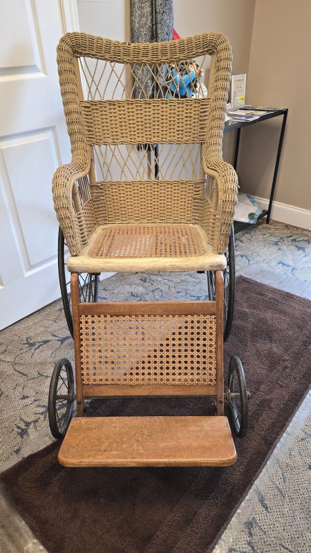 Antique wicker wheelchair on carpeted floor