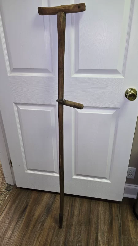 Antique handmade wooden crutch with pivoting hand rest and metal tip