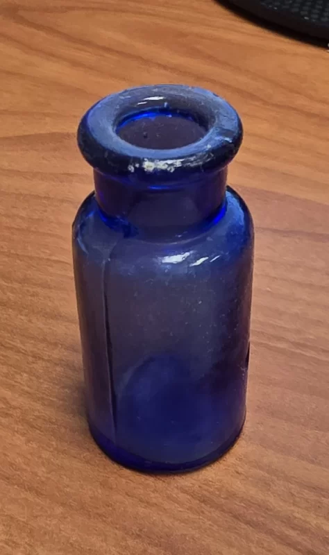 Close-up of antique cobalt blue apothecary bottle used for medicinal storage