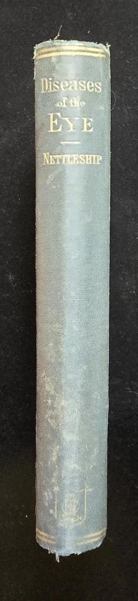 Title and author “Diseases of the Eye – Nettleship” in gilt on frayed green cloth.