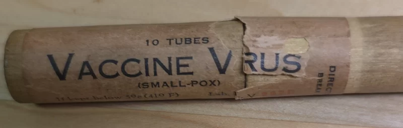 Wooden tube container labeled "Vaccine Virus (Smallpox)" from Gilliland Laboratories, circa 1920s