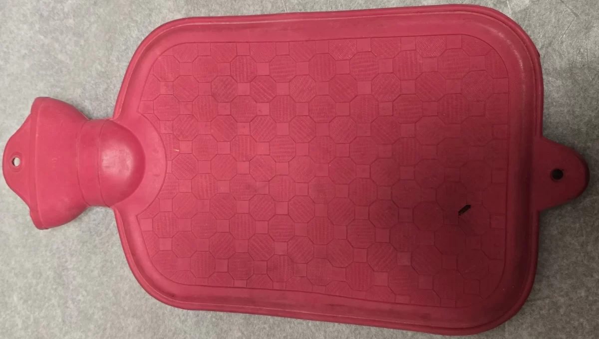 Top view of vintage rubber hot water bottle with red textured surface