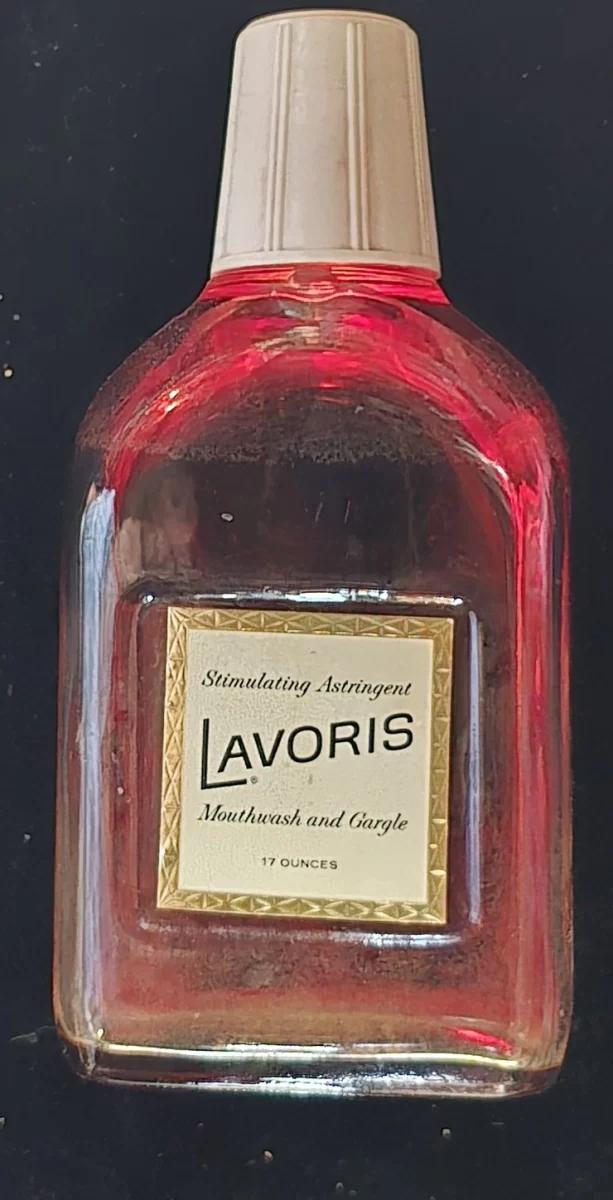 Vintage glass bottle with red liquid and a cream-colored plastic cap; front label reads "Lavoris Stimulating Astringent Mouthwash and Gargle, 17 Ounces."
