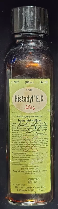 Vintage Histadyl E.C. cough syrup bottle with original label, showing ingredients and exempt narcotic classification.