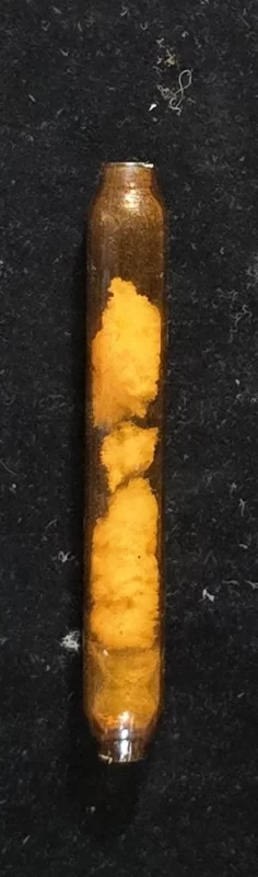 vintage glass inhaler tube with cotton wadding viewed from side