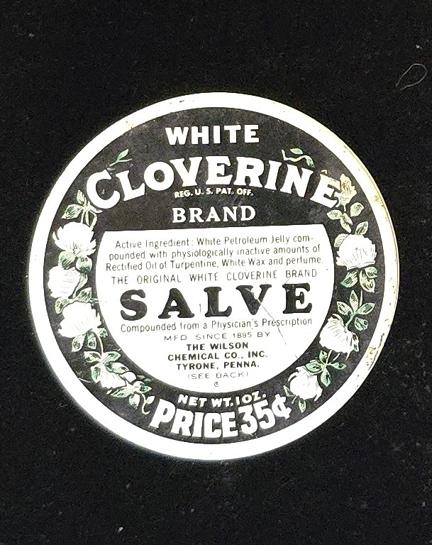 Front of White Cloverine Brand Salve tin with floral design