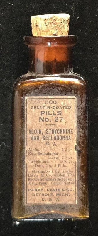 Parke Davis Pills No. 27 amber apothecary bottle with cork stopper and label listing aloin, strychnine, and belladonna.