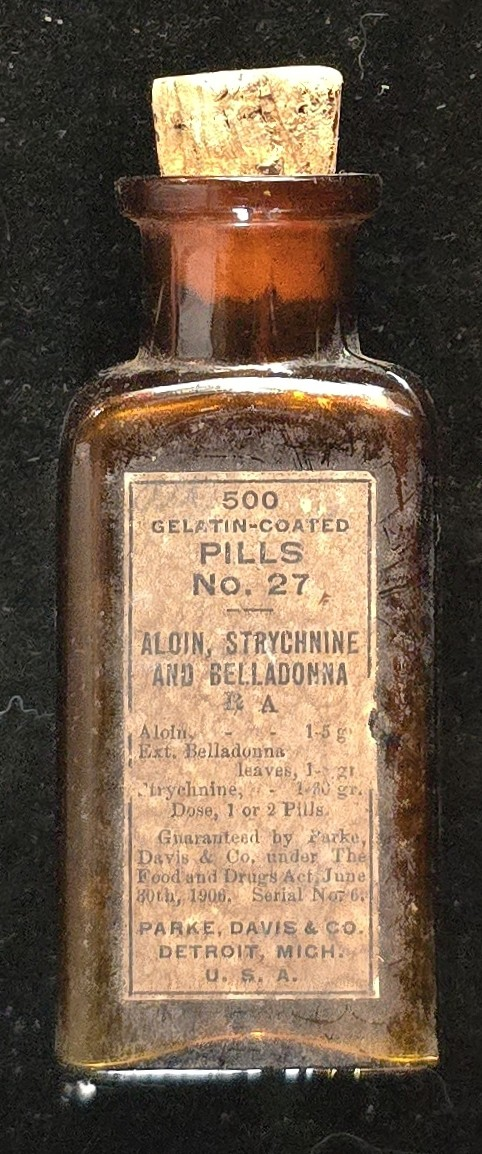 Parke Davis Pills No. 27 amber apothecary bottle with cork stopper and label listing aloin, strychnine, and belladonna.