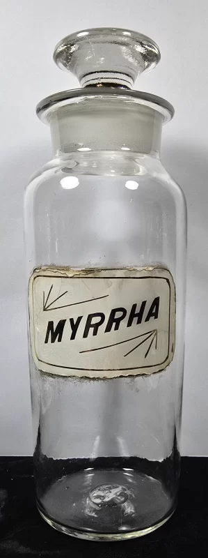 ntique glass apothecary jar labeled Myrhha with ground glass stopper
