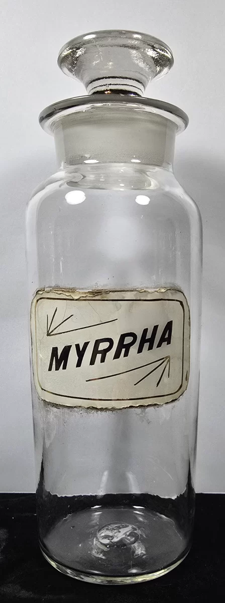 ntique glass apothecary jar labeled Myrhha with ground glass stopper