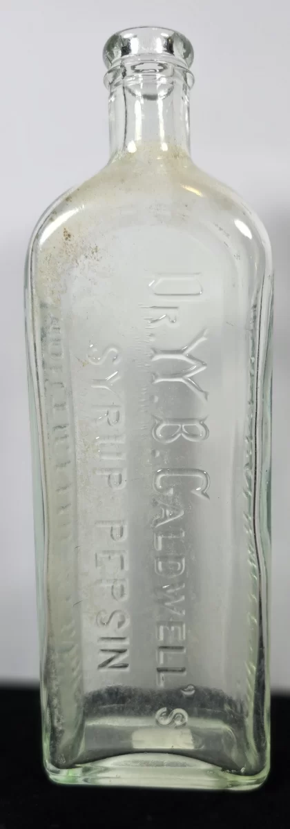 Antique embossed bottle reading “Dr. W. B. Caldwell’s Syrup Pepsin, Monticello, Illinois,” clear glass patent medicine container.
