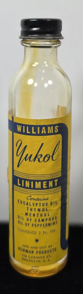 Vintage Williams Yukol Liniment bottle with yellow label, containing menthol, camphor, and eucalyptus oil.
