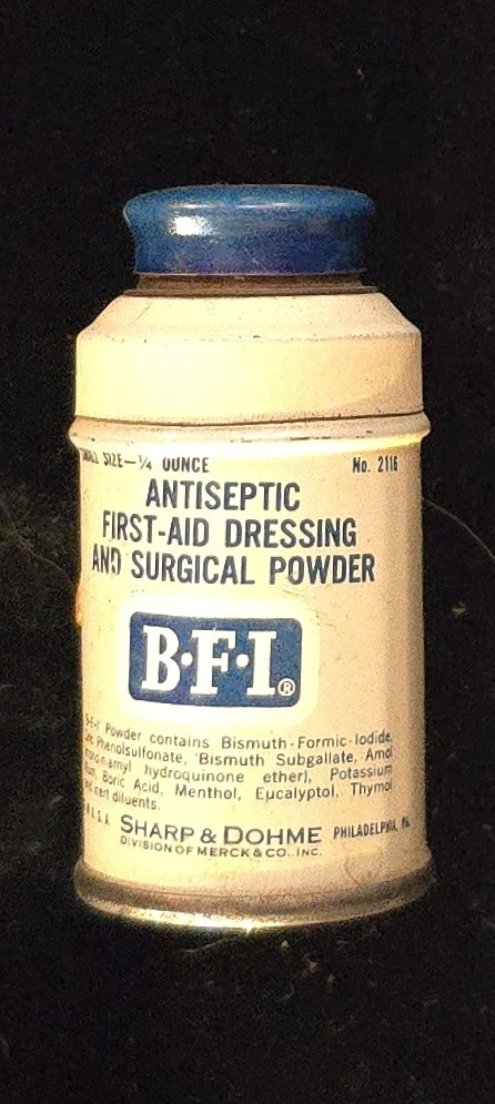 Vintage Sharp & Dohme B.F.I. Antiseptic First-Aid Dressing and Surgical Powder tin with blue cap and white label, Philadelphia, PA, mid-20th century.