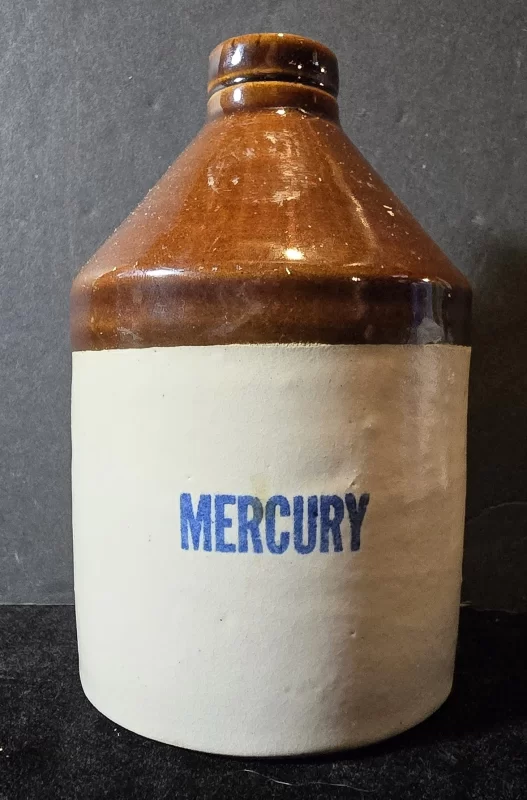 Antique brown-top stoneware jug labeled “MERCURY,” used for storing elemental mercury in early apothecaries.