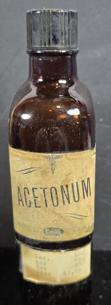 Amber Sharp & Dohme Acetonum bottle, 1930s–1950s, with Latin acetone label and intact price chart.