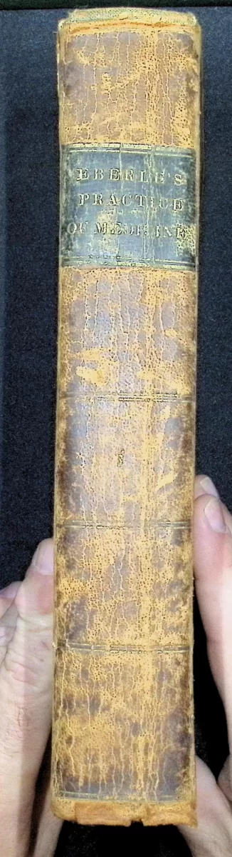 1835 leather-bound volume of Eberle’s Treatise on the Practice of Medicine with worn spine and foxed title page.