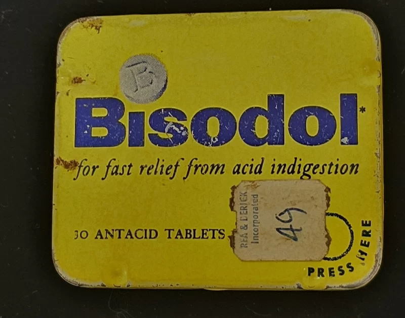 Vintage yellow Bisodol antacid tin with blue lettering and Rea & Derick price sticker.