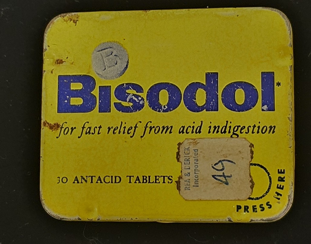 Vintage yellow Bisodol antacid tin with blue lettering and Rea & Derick price sticker.