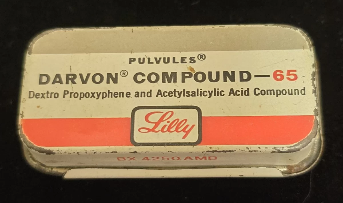 Vintage Eli Lilly Darvon Compound-65 Pulvules metal tin with red and white label showing propoxyphene and aspirin combination.