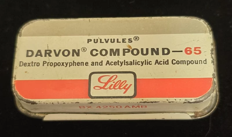 Vintage Eli Lilly Darvon Compound-65 Pulvules metal tin with red and white label showing propoxyphene and aspirin combination.