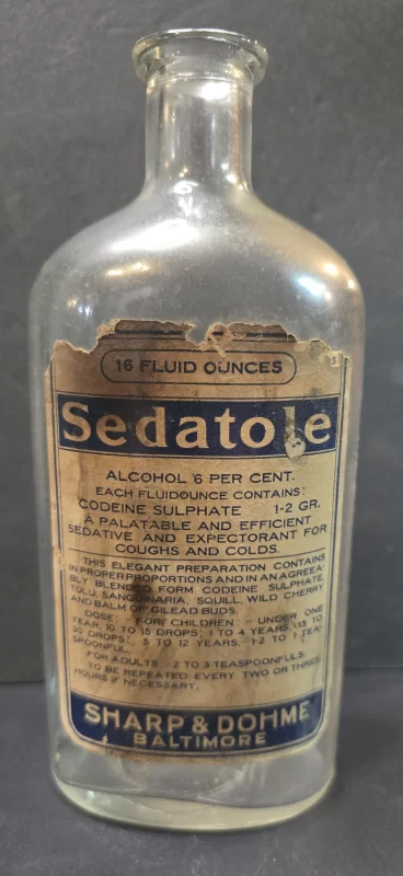 Antique Sedatole bottle by Sharp & Dohme with partially intact label listing codeine sulphate and alcohol.