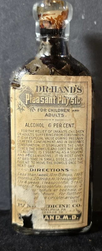 Amber glass bottle of Dr. Hand’s Pleasant Physic with original paper label detailing pediatric and adult dosing instructions and 6 percent alcohol content.