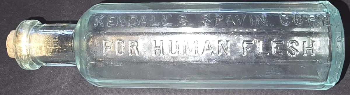 Embossed aqua glass bottle labeled “Kendall’s Spavin Cure for Human Flesh”