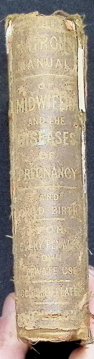 Worn cloth spine of The Matron’s Manual of Midwifery, 1876 edition