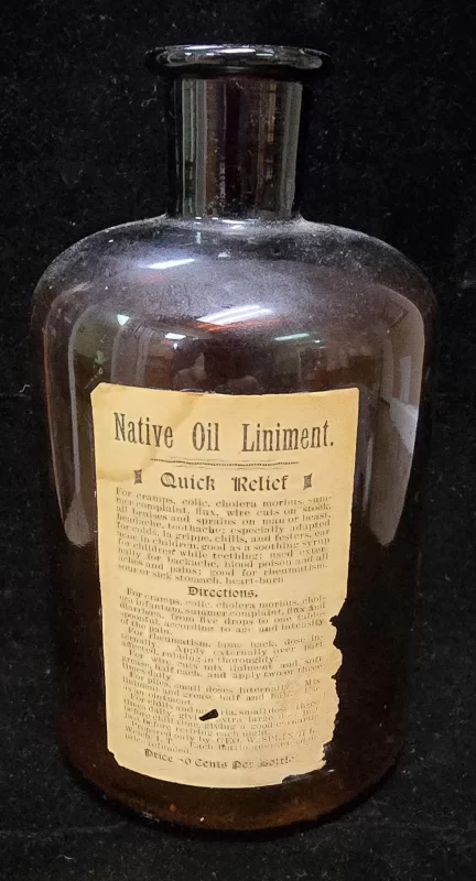Front view of antique Native Oil Liniment amber glass bottle with original paper label