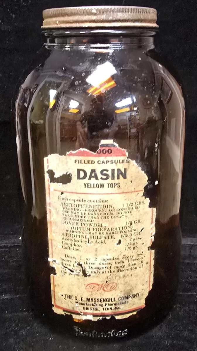 Antique amber glass Dasin Yellow Tops capsule bottle by The S. E. Massengill Company with worn original label and metal screw cap