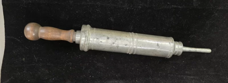 Antique metal clyster syringe with wooden plunger and detachable nozzle, circa 1880–1910