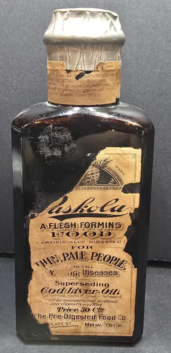 Original sealed Paskola Flesh Forming Food bottle with partial label, foil cap, embossed pineapple trademark, and original contents, circa 1890s.