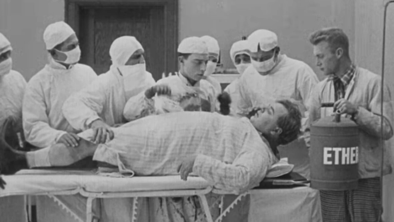 Black-and-white scene from the 1918 silent comedy Good Night, Nurse!, showing Buster Keaton, Fatty Arbuckle, and other performers in a chaotic operating room scene.